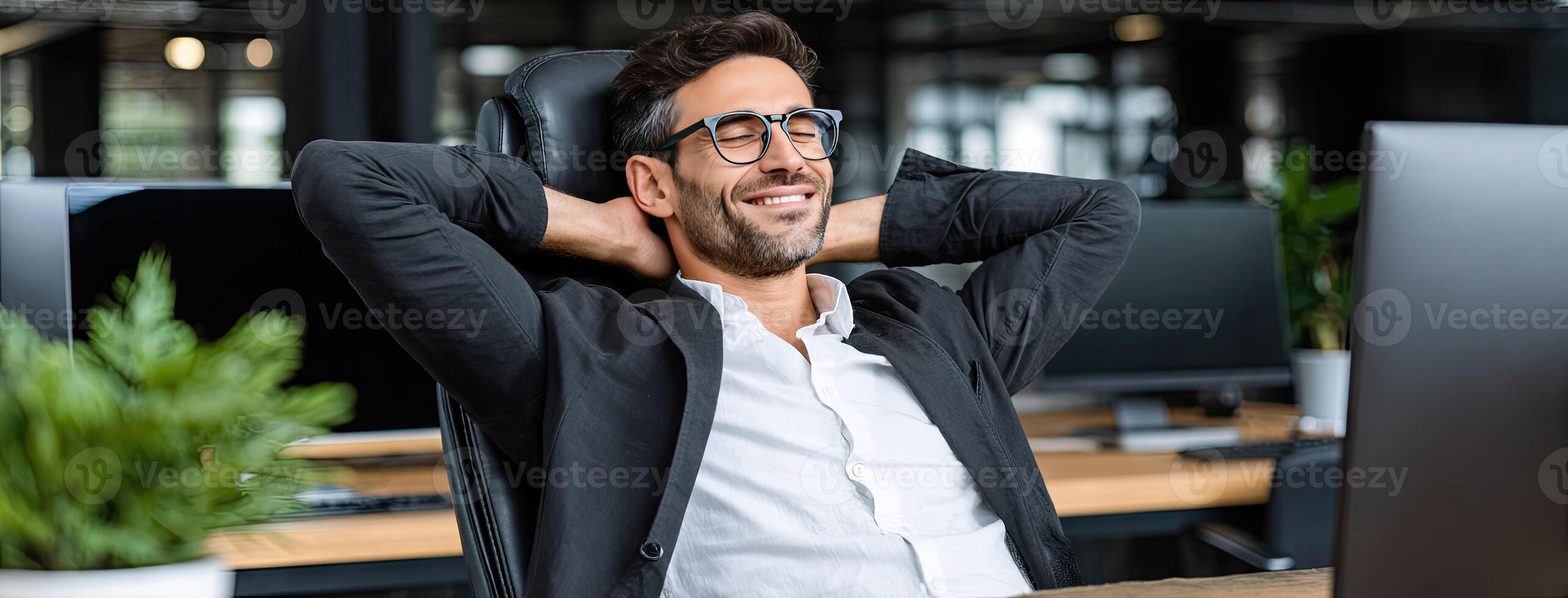 A man in glasses is relaxing in front of a computer photo
