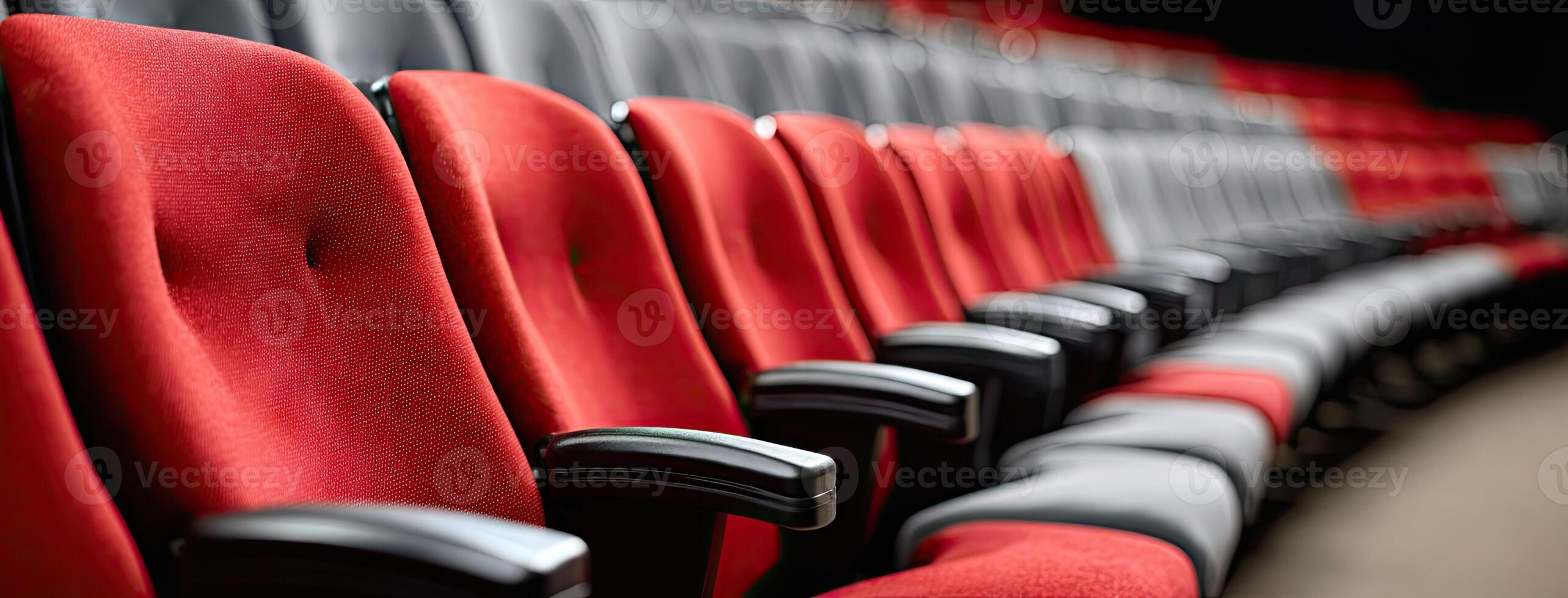 Rows of red and grey seats in an auditorium photo