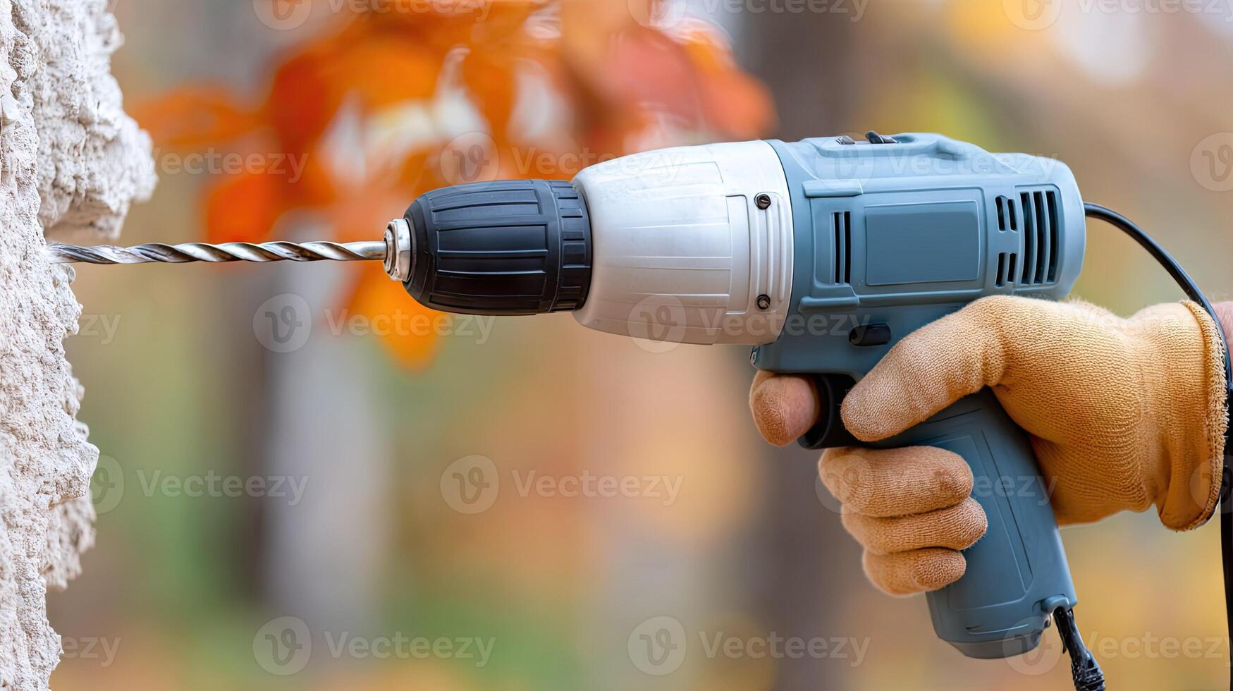 A person is using an electric drill to cut a tree photo
