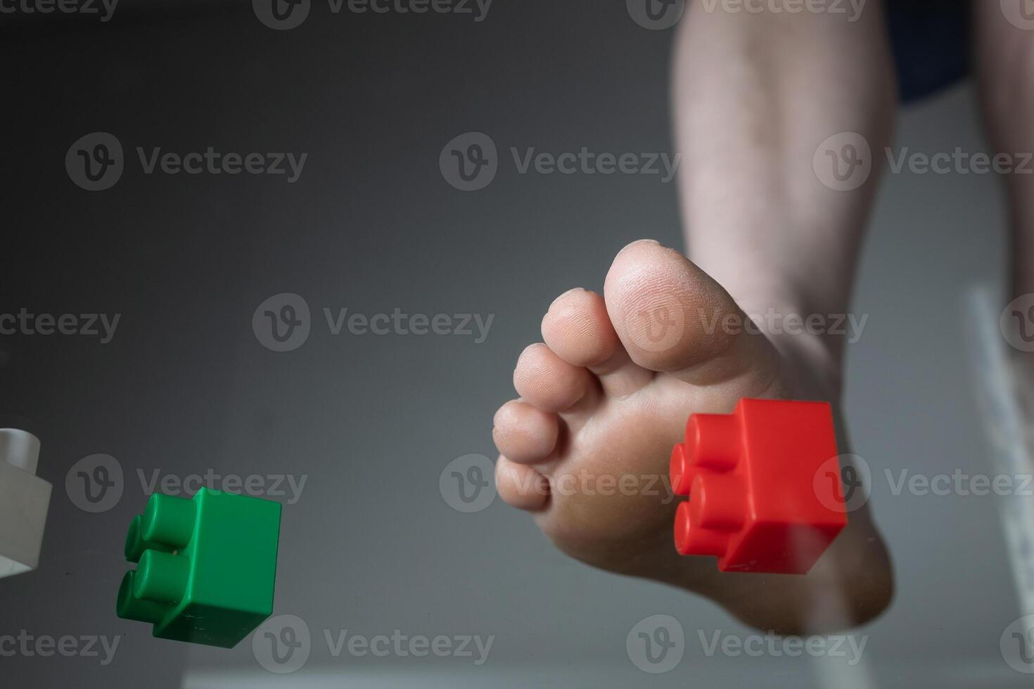 Foot Experiencing Pain Due to Stepping on Construction Toy Blocks in a Household Environment photo