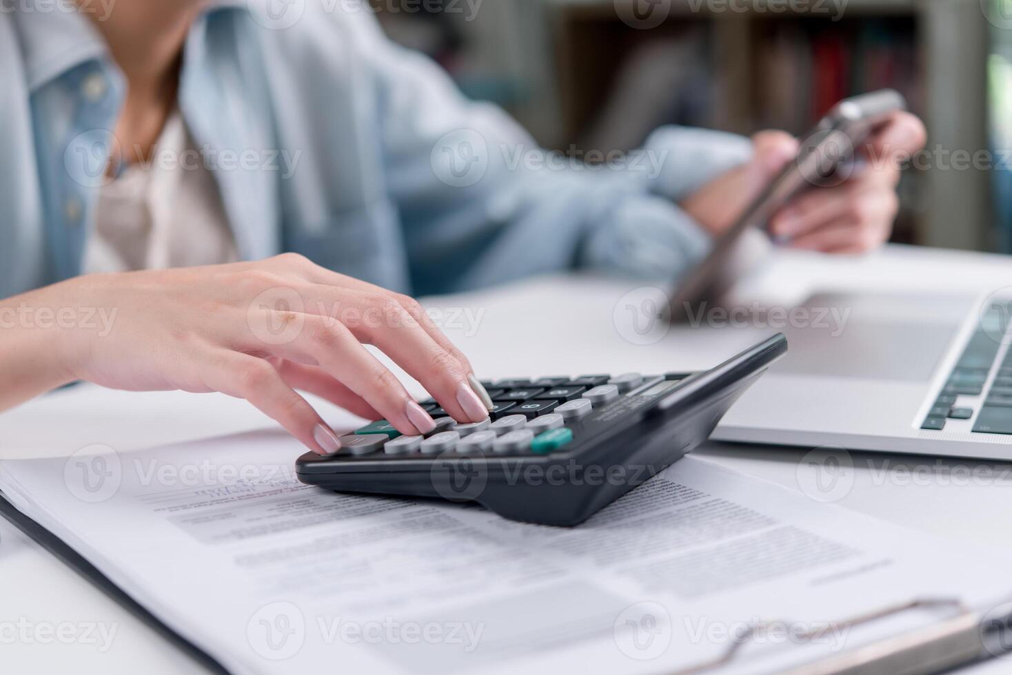 A person using a calculator on a desk photo