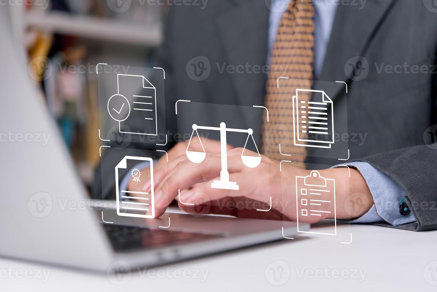A man in a suit is typing on a laptop with icons on it photo
