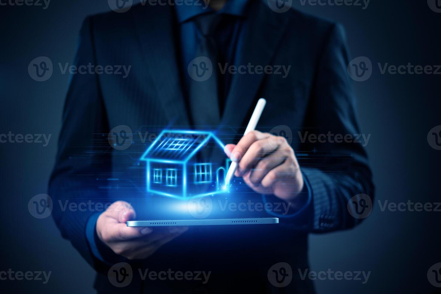 Businessman holding tablet with house icon on dark background photo