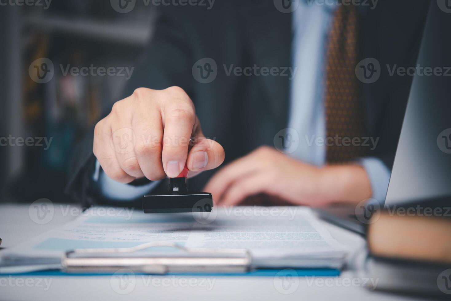 A person in a suit is holding a stamp photo