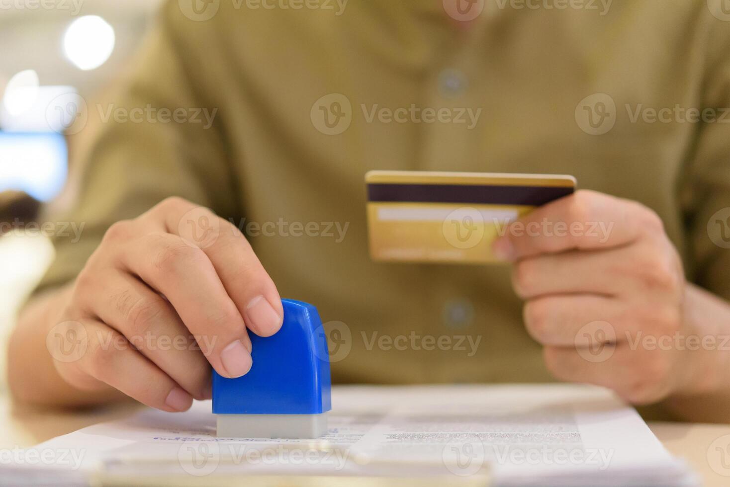 A man holding a credit card and a rubber stamp photo