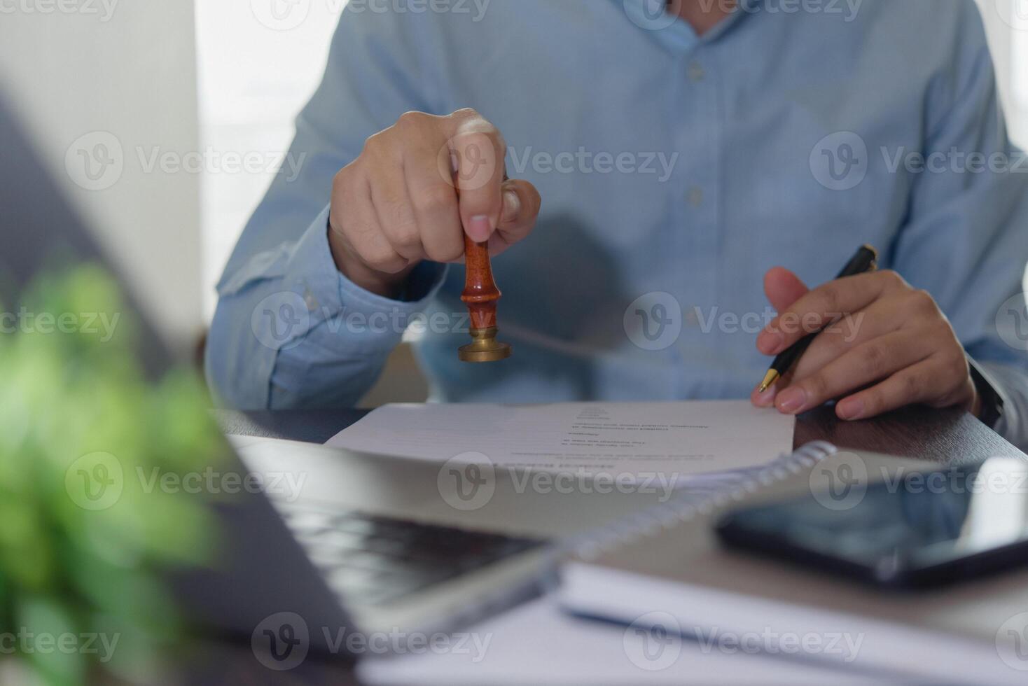 A man is holding a gavel in front of a laptop photo