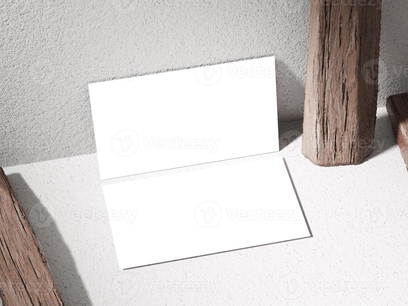 Business card mockup atop a stone with rough textures, surrounded by rustic wooden logs. photo