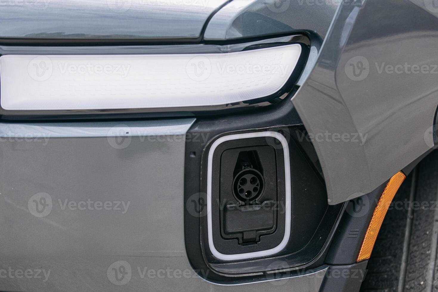 Close-up of the charging port in an electric vehicle near the headlight. The details of the port are clearly visible, highlighting the modernity photo