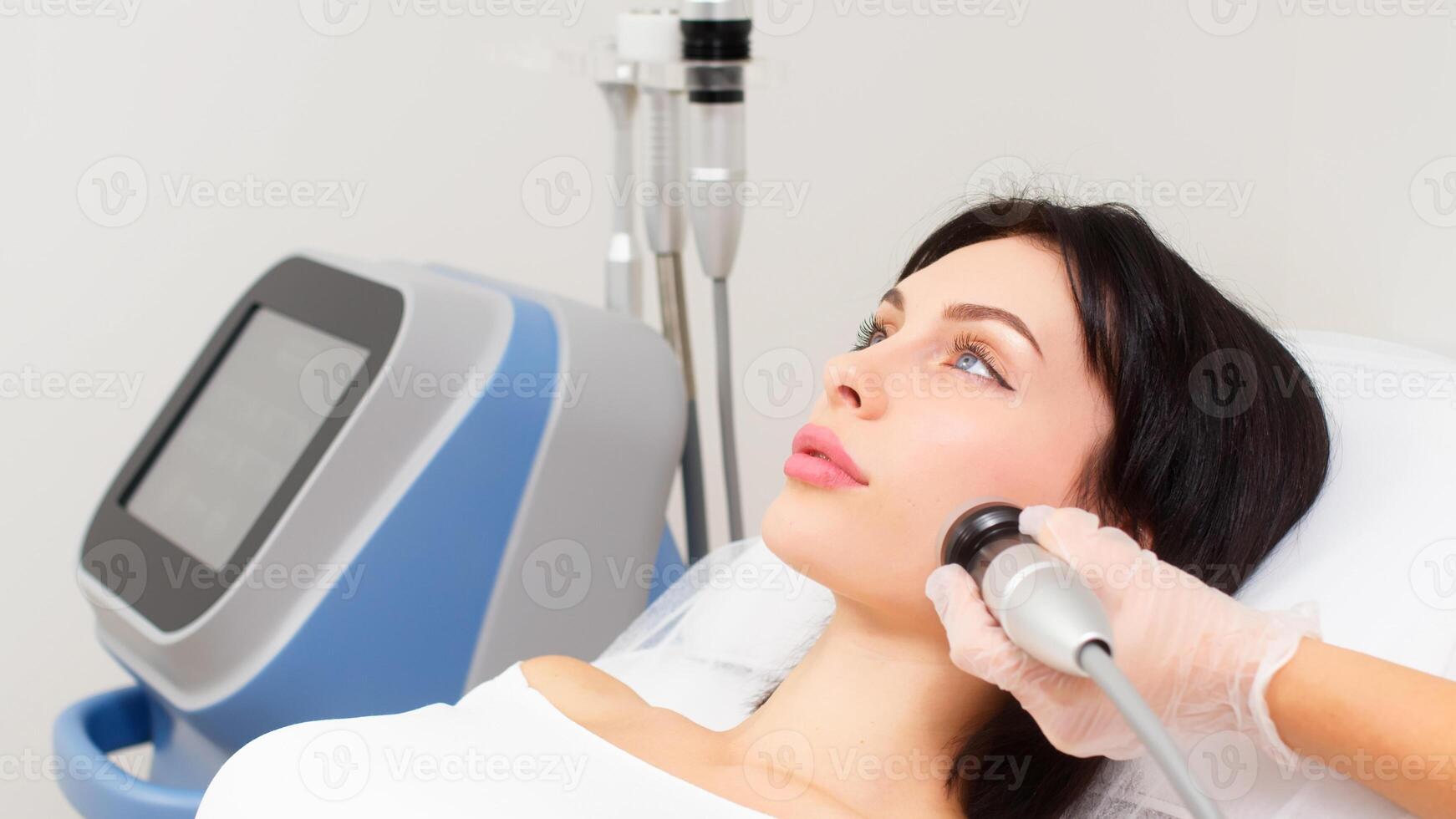 Close-up of a young girl undergoing fractional radiofrequency facelift at a medical center, skin rejuvenation concept. photo