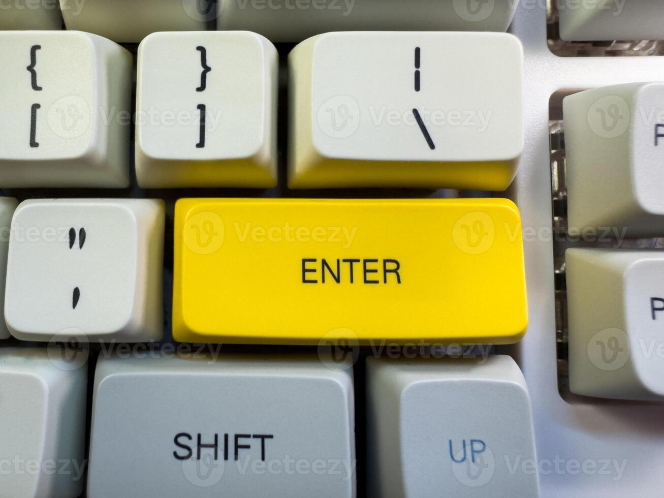 A computer keyboard with an yellow Enter photo