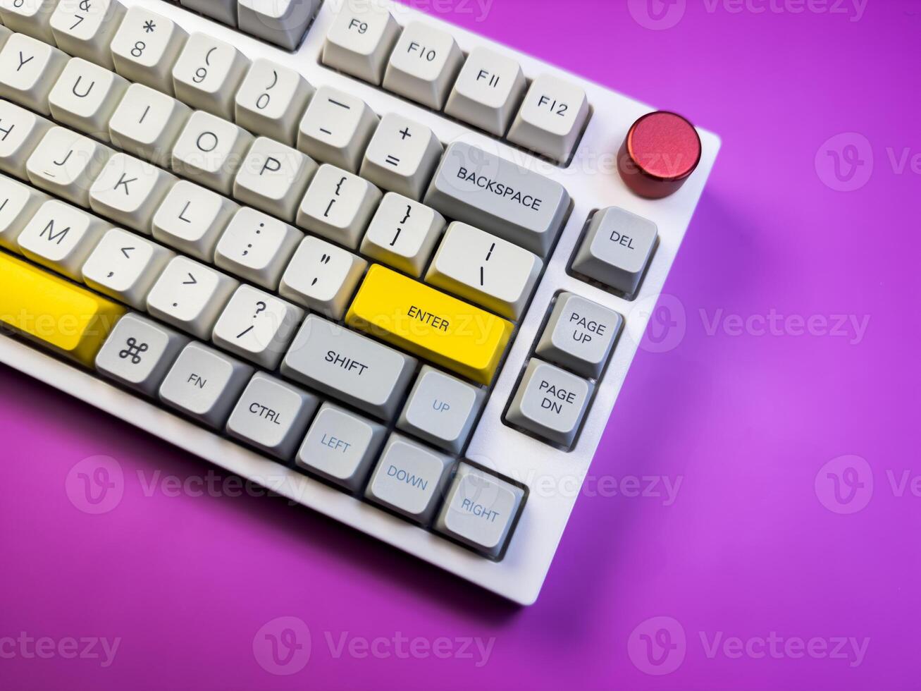 Modern mechanical keyboard isolated with red button on purple background. Minimal style and design keyboard. Colorful key cap. photo