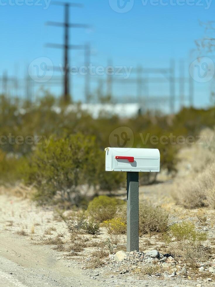 An isolated white metal US mail box on wooden post in the countryside. Mail concept. United States photo