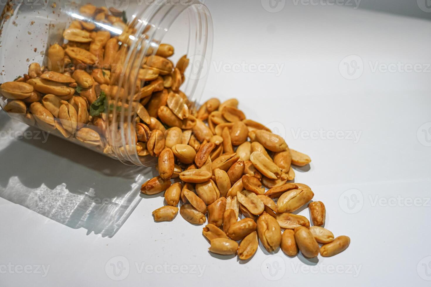 A jar of peanuts on a white surface photo