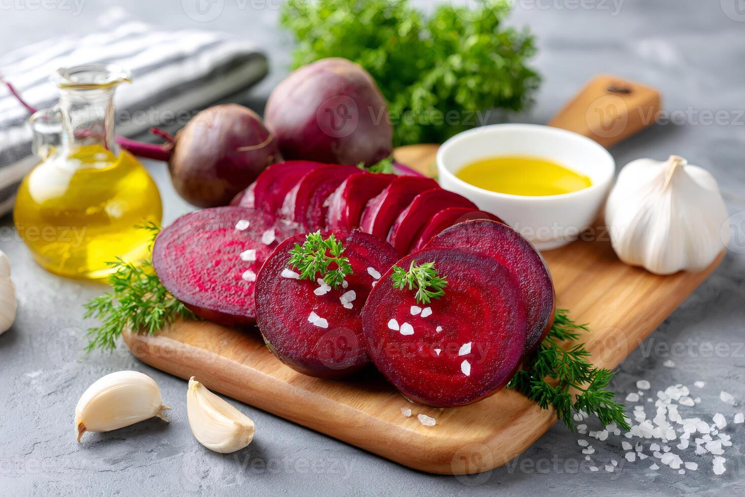 Sliced beetroot seasoned with salt and herbs on wooden cutting board photo