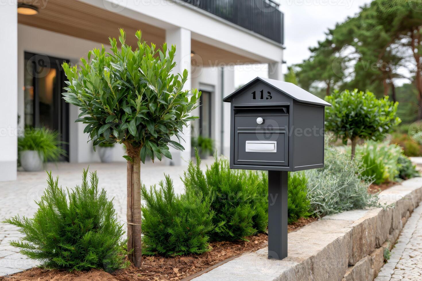Modern mailbox standing in front of a beautiful house photo
