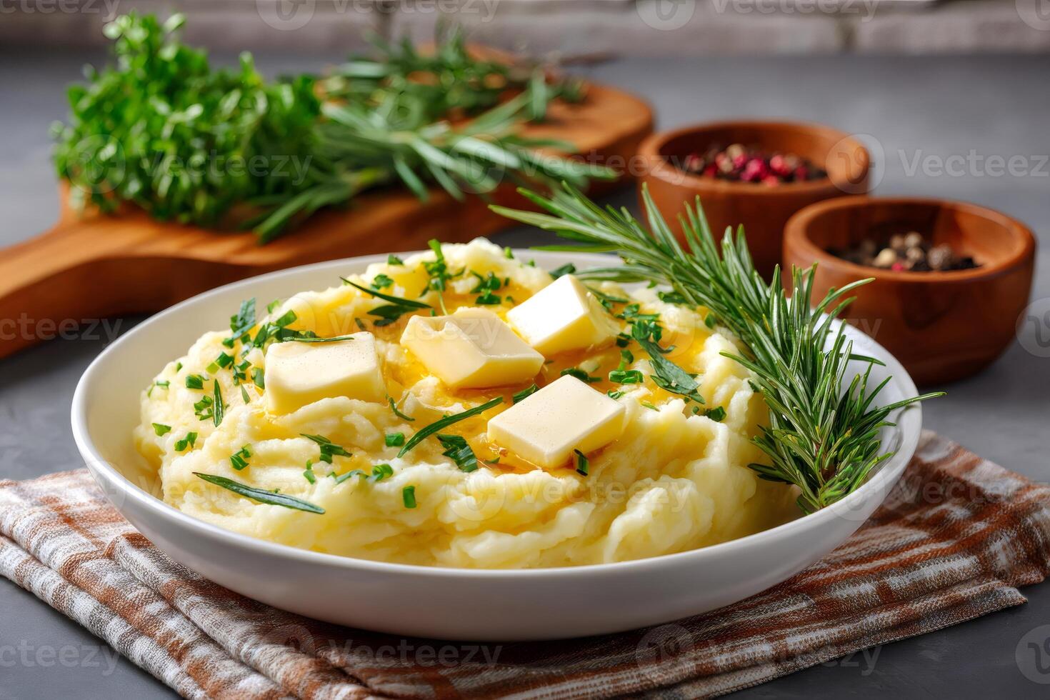 Creamy mashed potatoes with melted butter, herbs and rosemary in a bowl photo