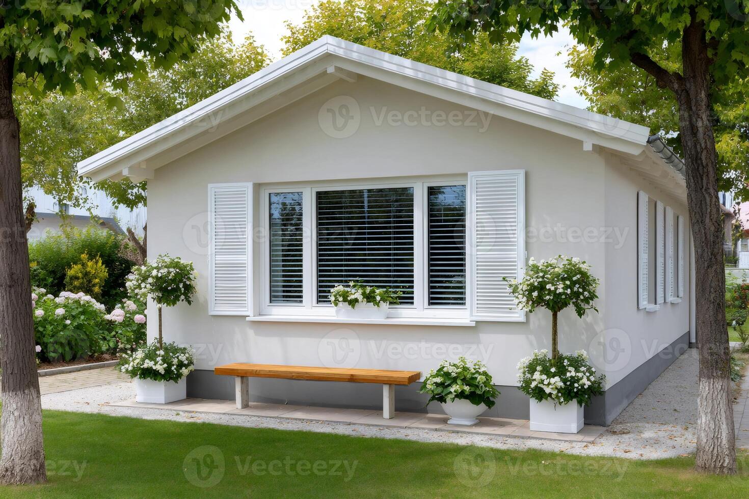 Pretty one-story house with white shutters and wooden bench enjoying summer sun photo