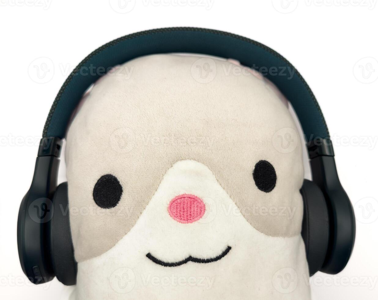 Dark green headphones on a plain white background are put on a soft toy, for banners, for advertising photo