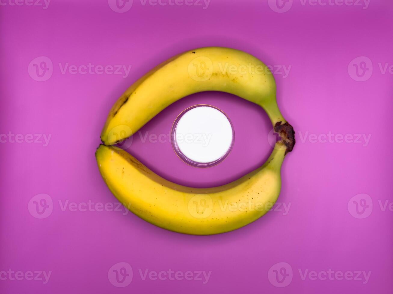 Two bright yellow bananas create a circle in which lies a jar with a white lid for medicines, top view, in the center of the image photo