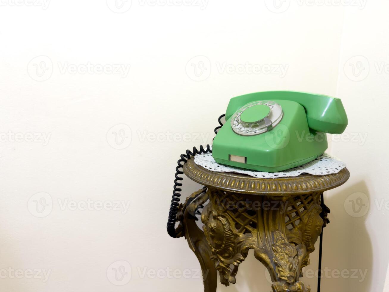 An old green phone is sitting on a gold stand. USSR phone. copy space photo