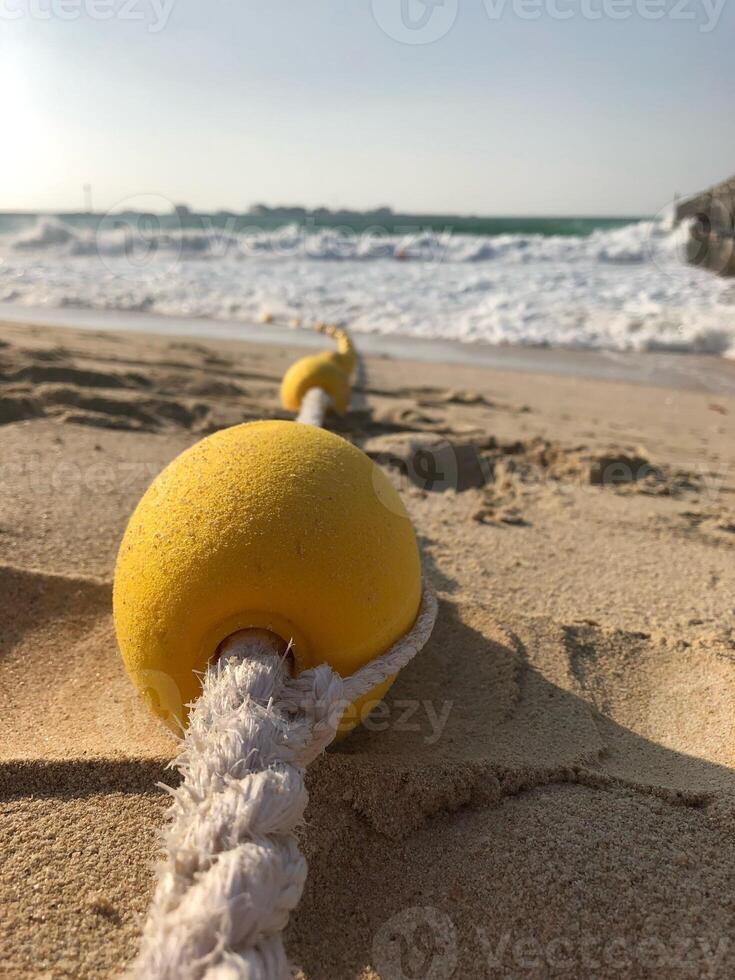 Small yellow buoy on a beach in Dubai at day photo