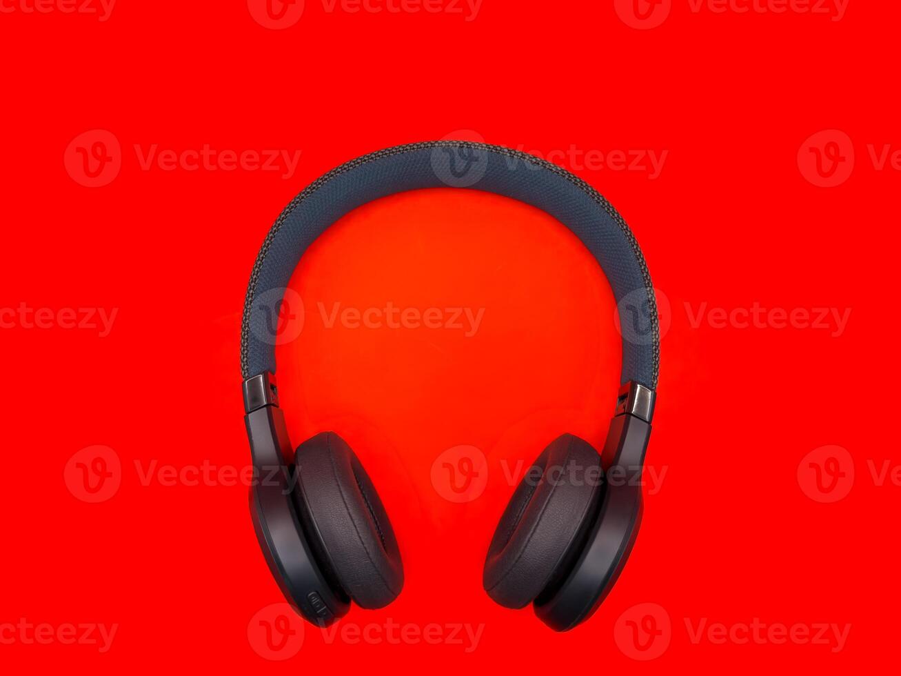 Dark green big headphones on a plain bright red background for banners, for advertising. copy space photo