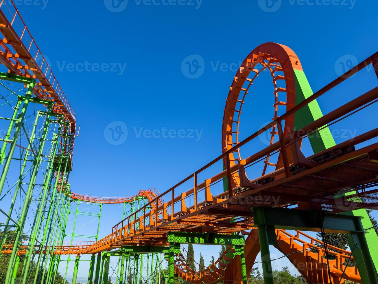 Orange roller coaster at an amusement park with cloudy blue sky, hang out and have fun outdoor at theme park on summer holiday. photo