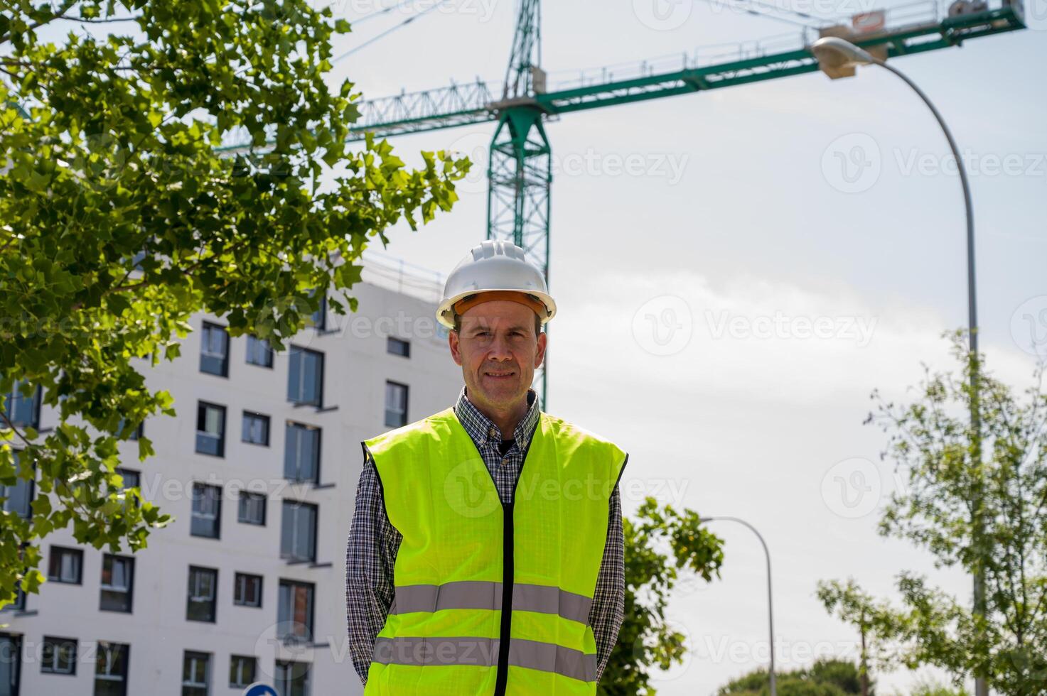 Professional male construction worker with safety helmet and reflective vest and safety glasses at a construction site with building progress timeless,,.. photo
