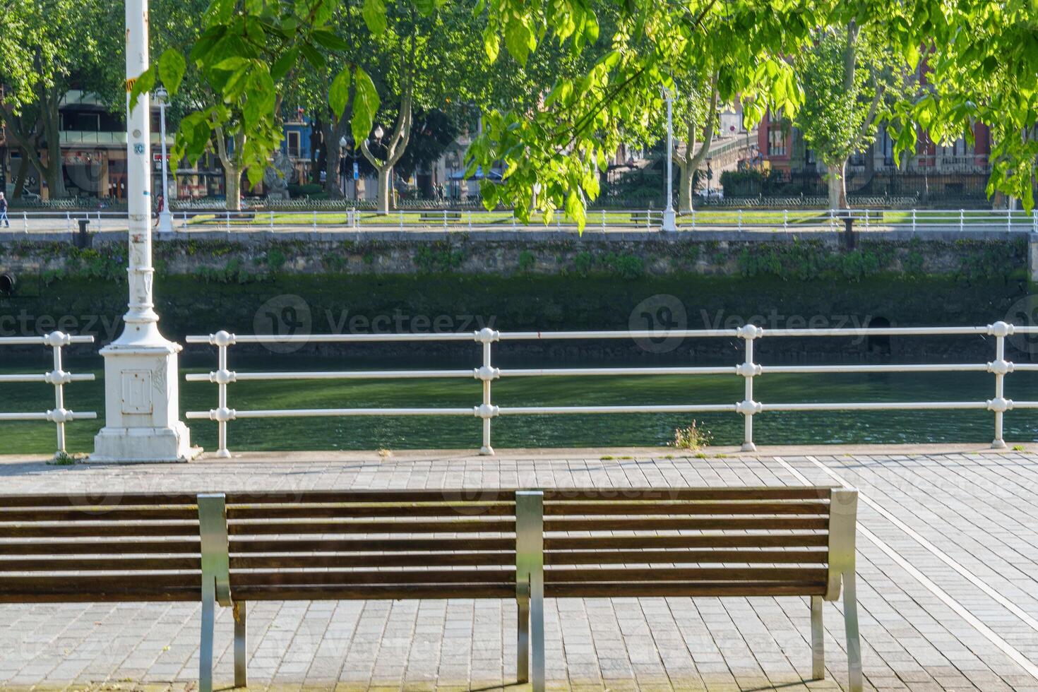 A bench sitting on a sidewalk photo