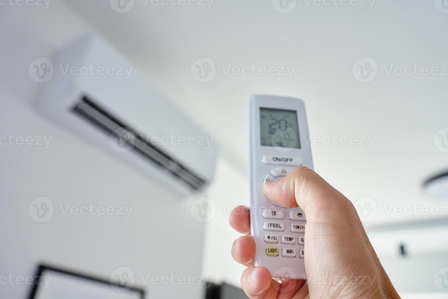 Using remote control to adjust temperature on air conditioner photo
