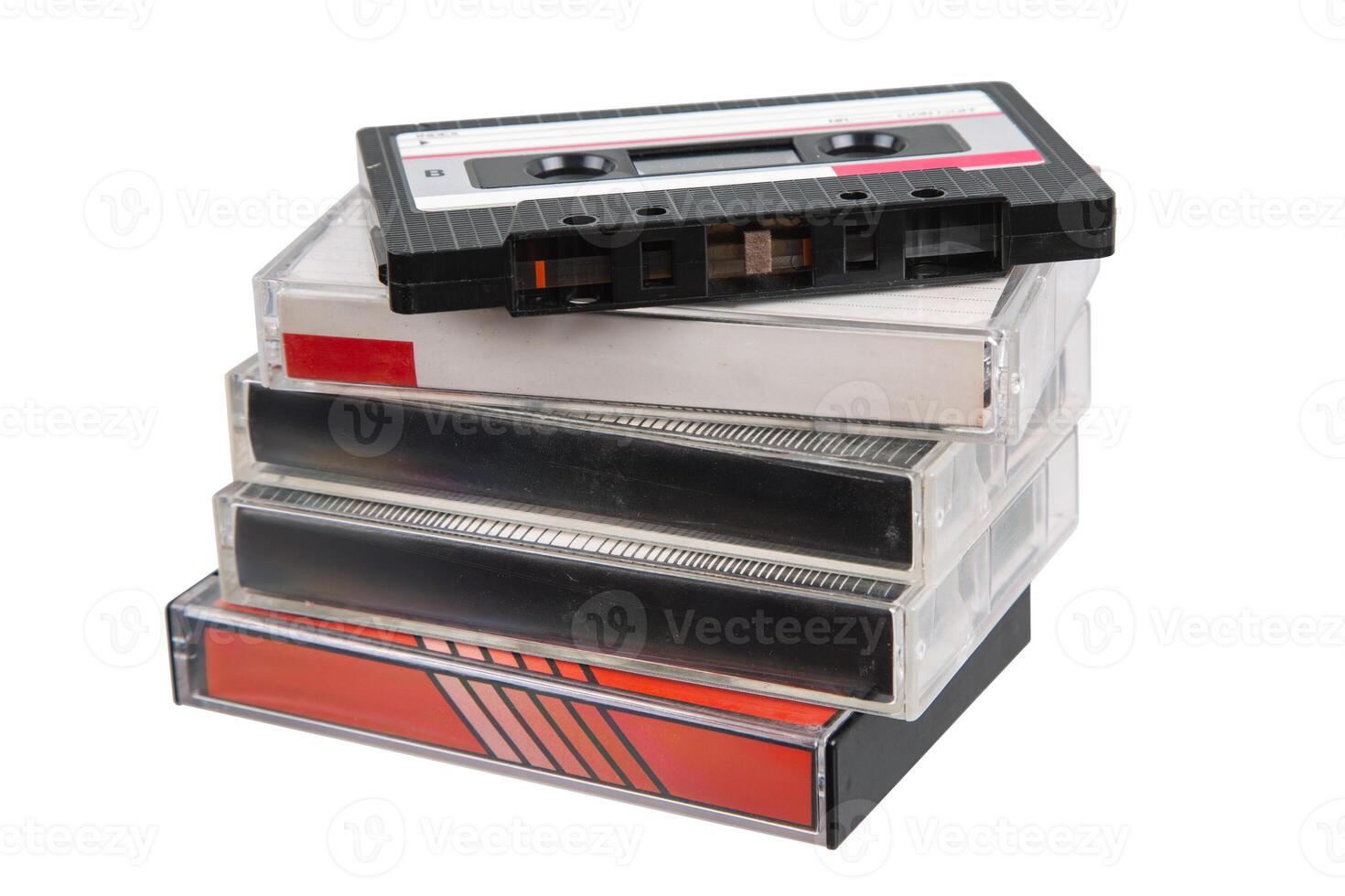 Retro magnetic tape cassette on top of a pile of plastic cases, isolated on white background. photo