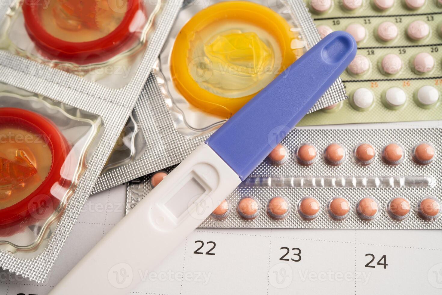 Pregnancy test birth control pills on calendar, contraception health photo