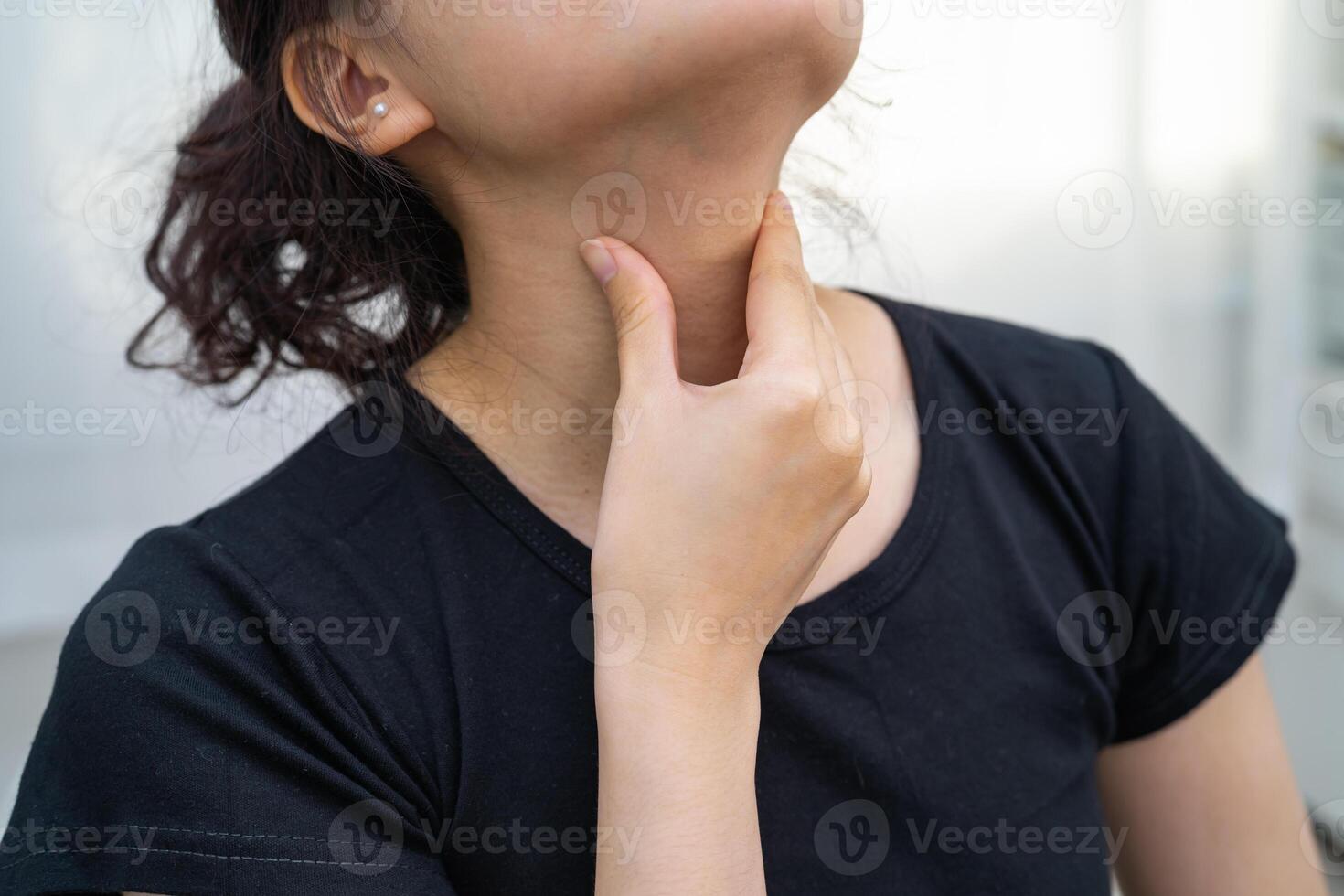 woman touching her neck and throat for thyroid gland photo