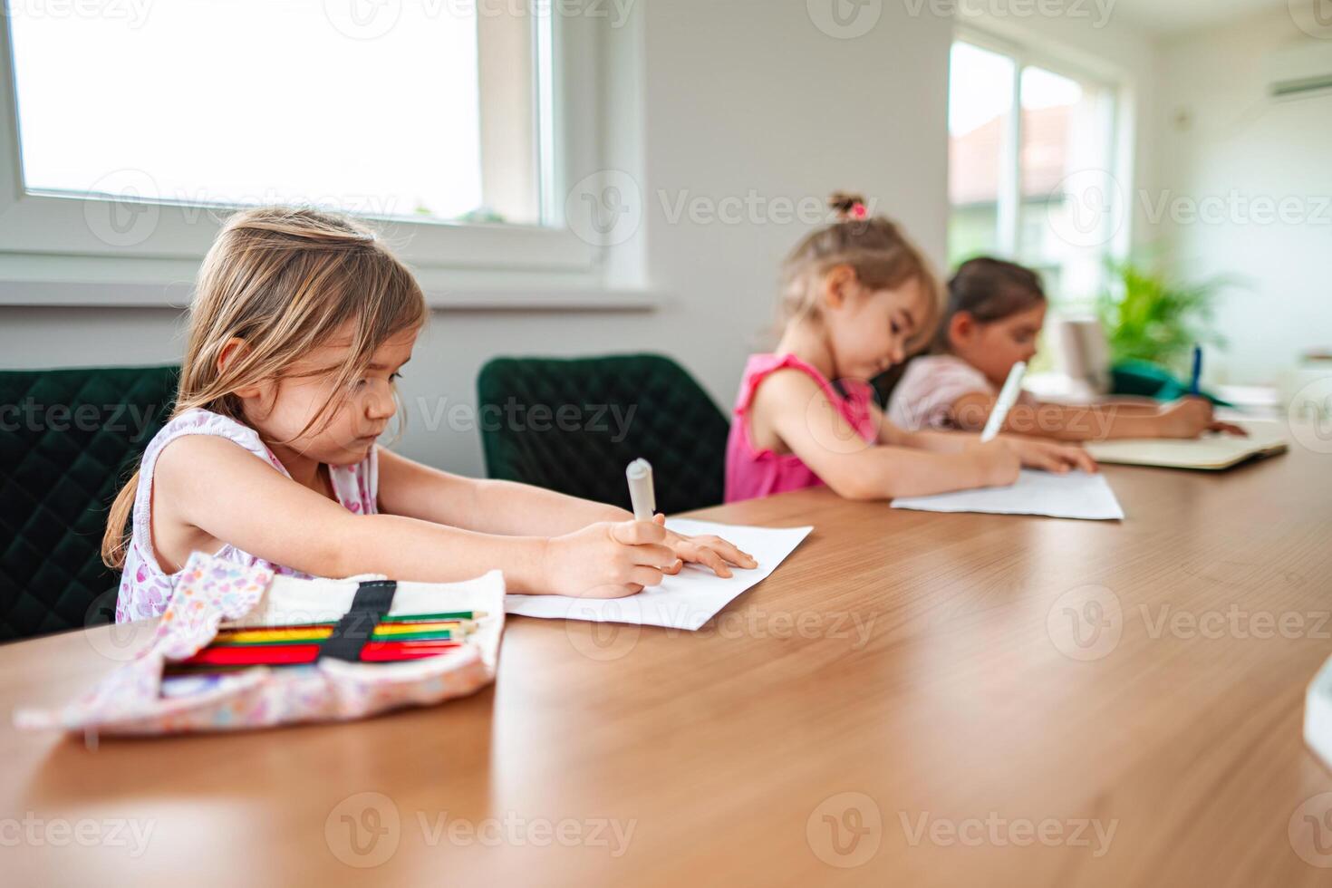 Children engaged in creative drawing at a cozy table photo
