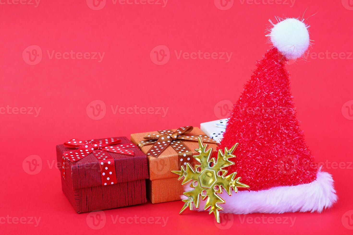 santa claus hat with gift boxes and gold snowflake on red photo