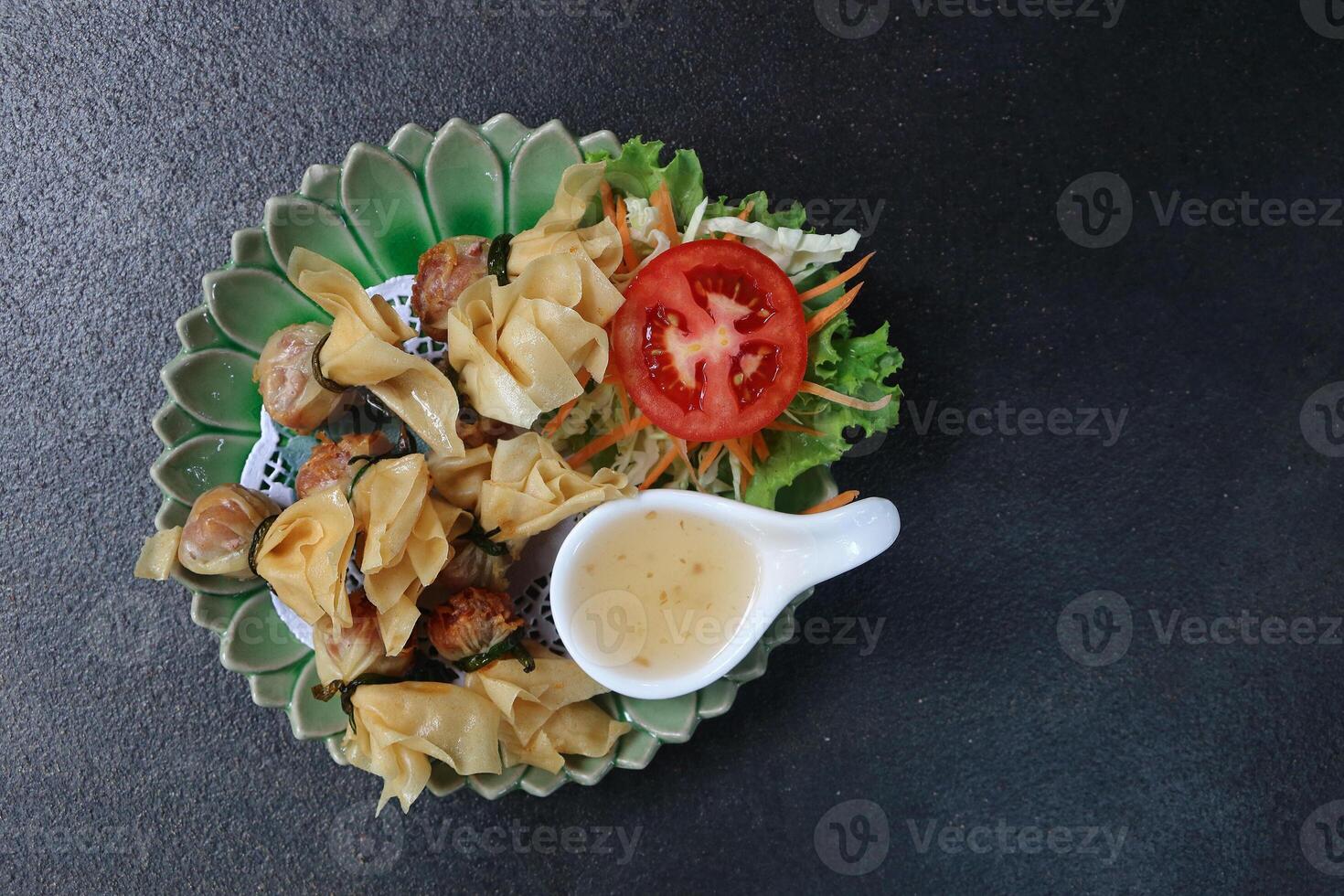 fried crispy meat spring roll with plum sauce and mixed vegetable served on circle zig zag plate photo