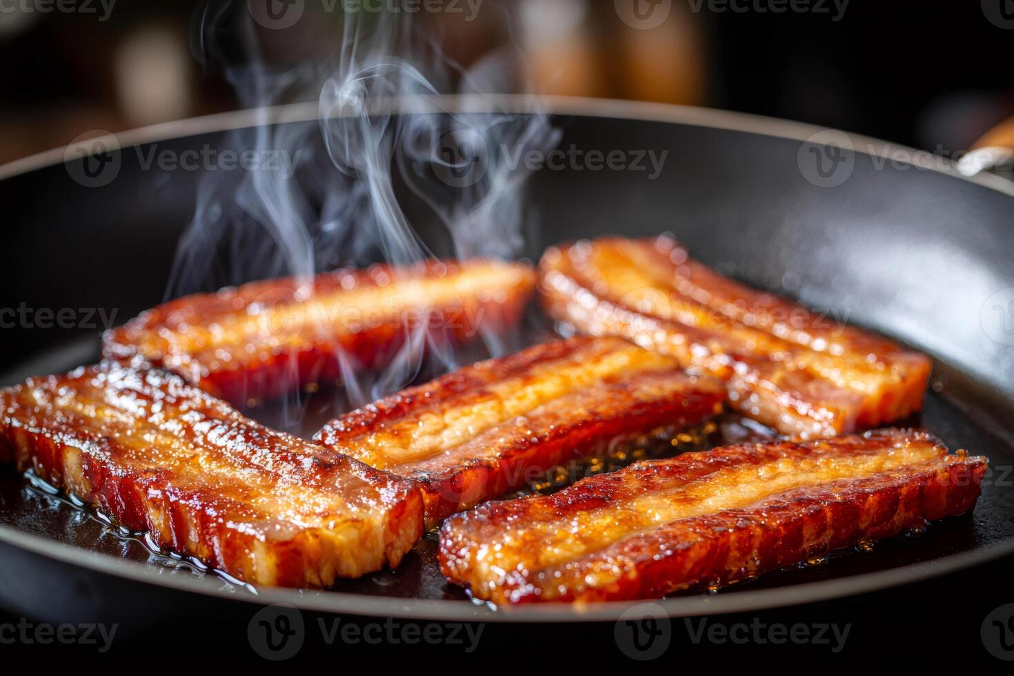 Delicious crispy bacon frying in pan with smoke photo