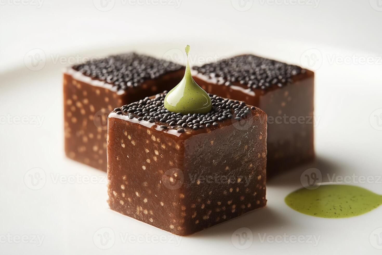 Delicious chocolate cubes covered with black sesame seeds and green sauce droplet in gourmet restaurant setting photo