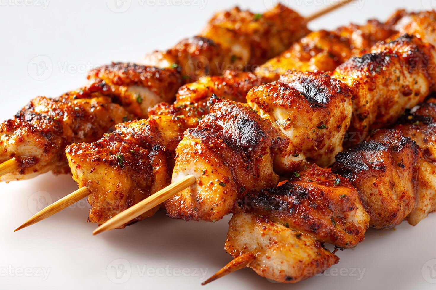 Delicious spicy chicken skewers grilled with perfect char on clean white surface photo