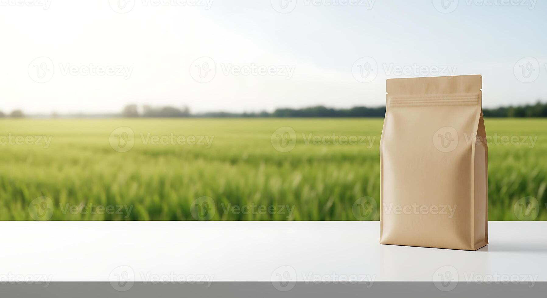 A bag of coffee on a table in front of a green field photo