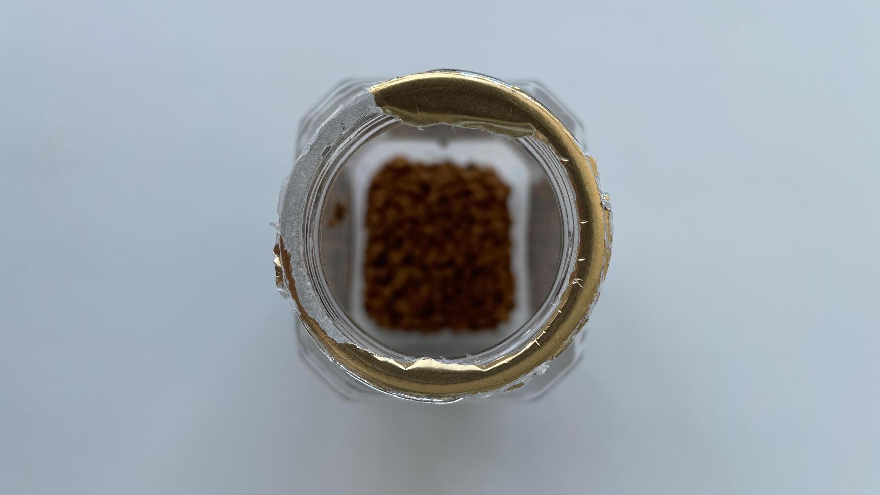 Empty jar of instant coffee close-up. The last grains of coffee are lying at the bottom of the jar. Diet food, nutrition, and clean eating themes, this image is ideal for food blogs, wellness articles, and healthy lifestyle promotions. High-resolution, is photo