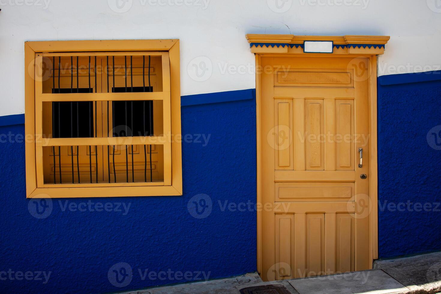 Beautiful facades of the colonial houses at the streets of the Heritage Town of Jerico located in the Department of Antioquia in Colombia. Blue, white and beige. photo