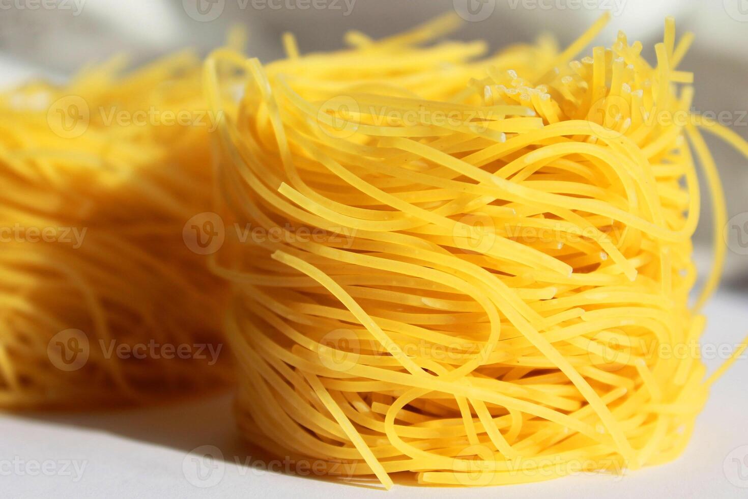 Raw pasta capellini on grey background photo