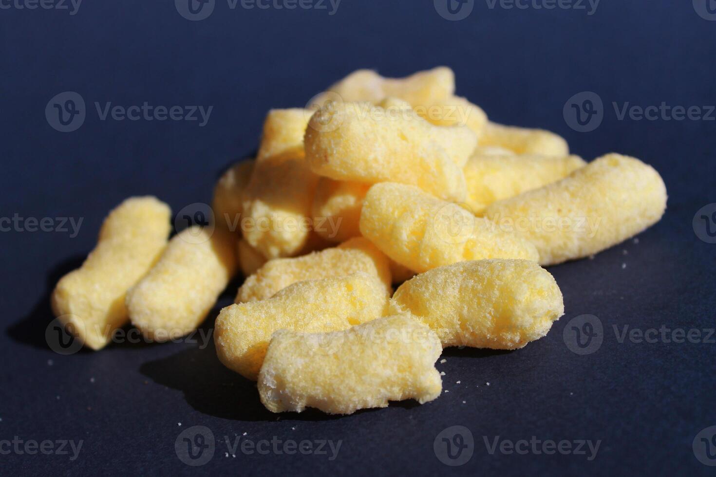 Delicious sweet corn sticks, isolated on dark blue background photo