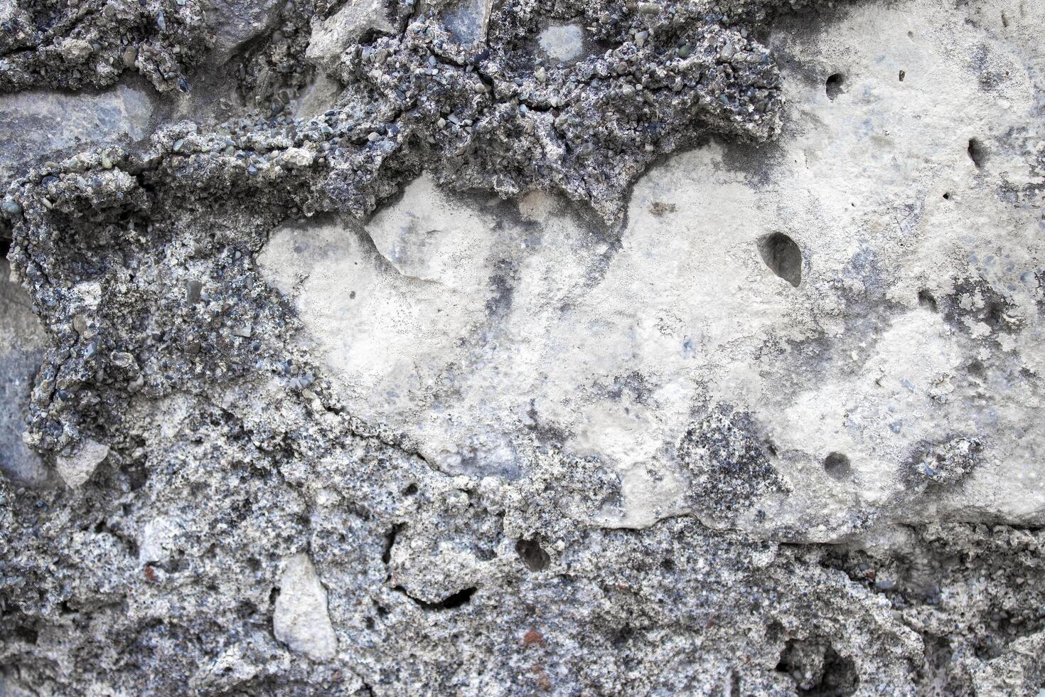 Ancient Stone Wall. Abstract Cement Background. The Texture of the Ancient Stone From Pebbles, Stones and Bricks Close-up photo