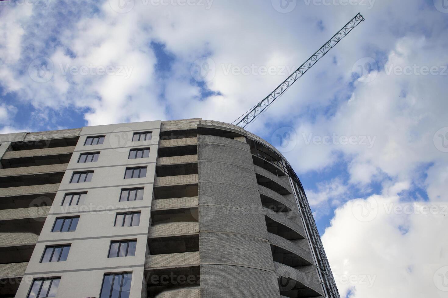 Construction of a Residential New House is Underway at the Construction Site of a Residential Complex. Background with Construction Site with Crane and Blue Sky. City Development. City Skyline. photo