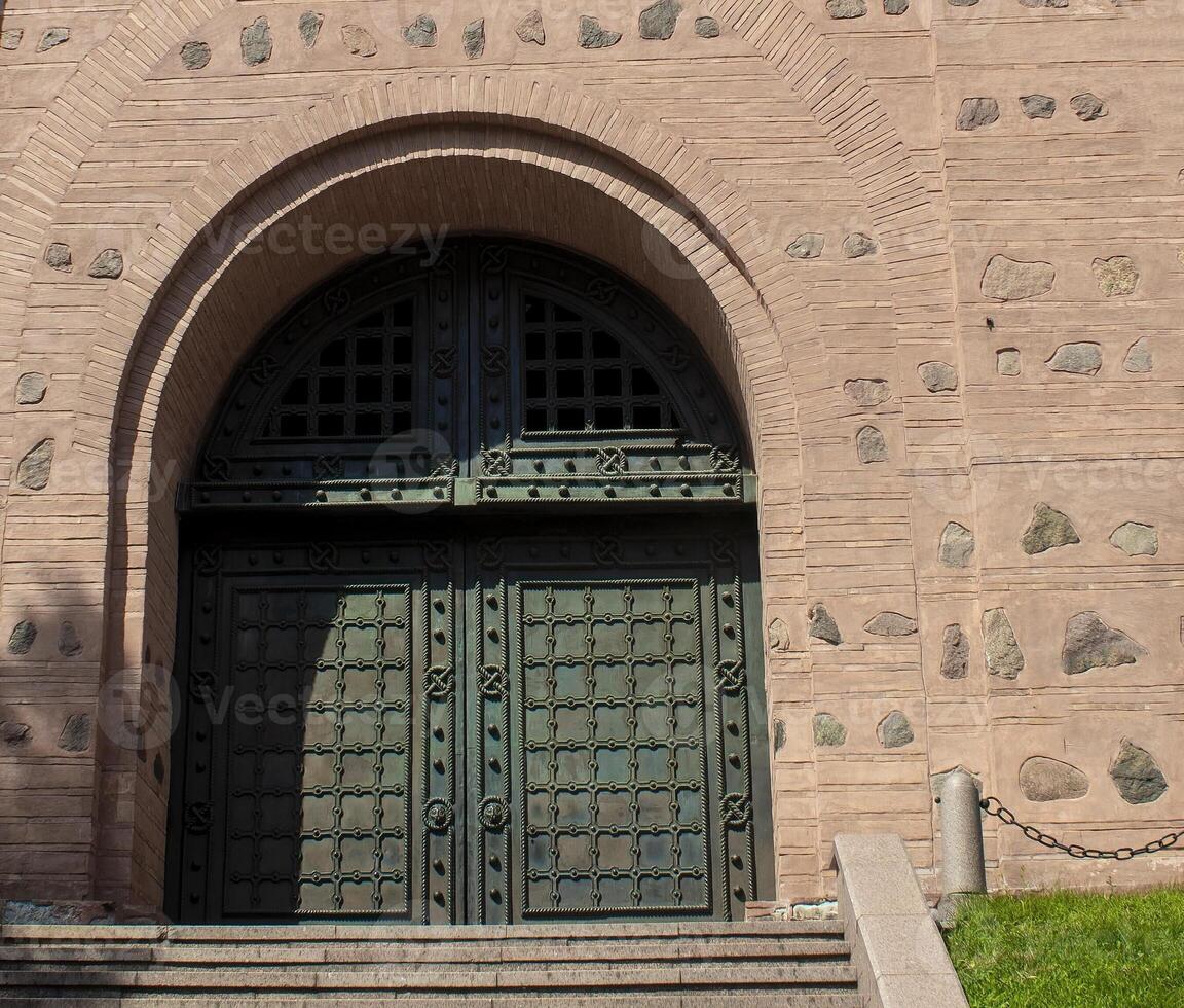 Wooden Arched Doors Surrounded by Stones in Medieval Design.  Castle Detail photo