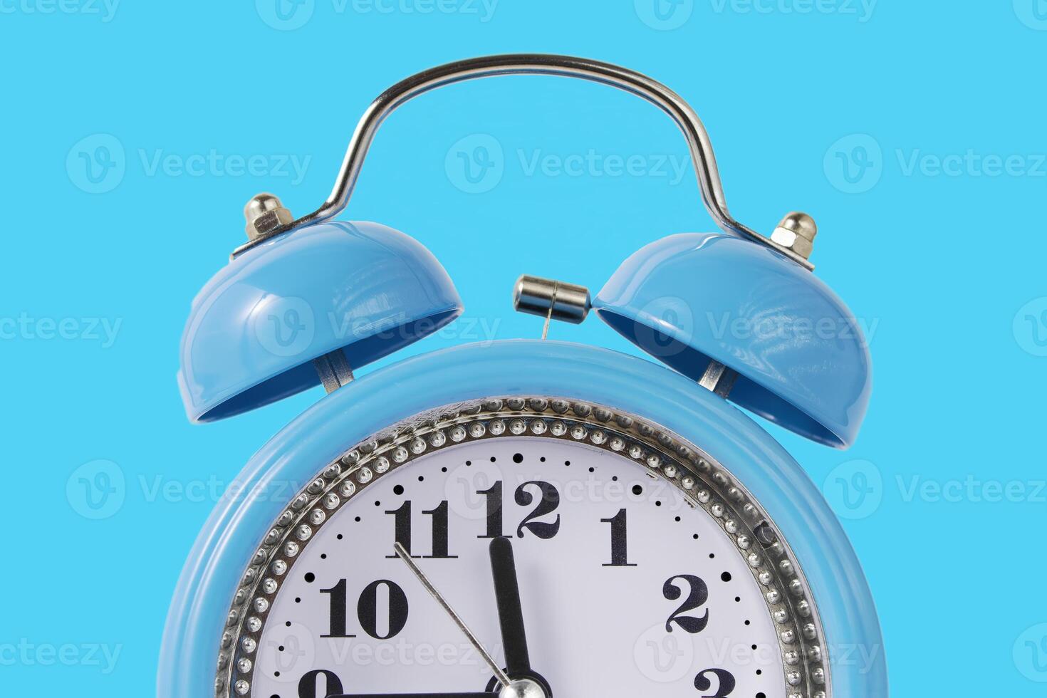 Retro Alarm Clock. Close up One Classic Alarm Clock on a Blue Background photo