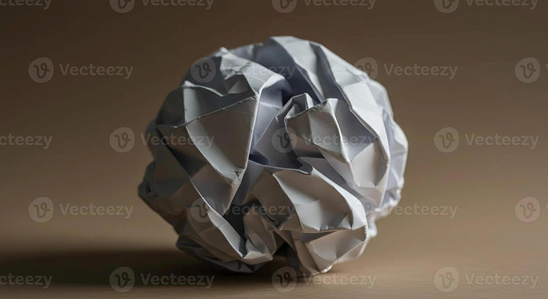 A simple ball of crumpled paper, showcasing texture and imperfection, symbolizing a discarded idea or a moment of creativity. photo