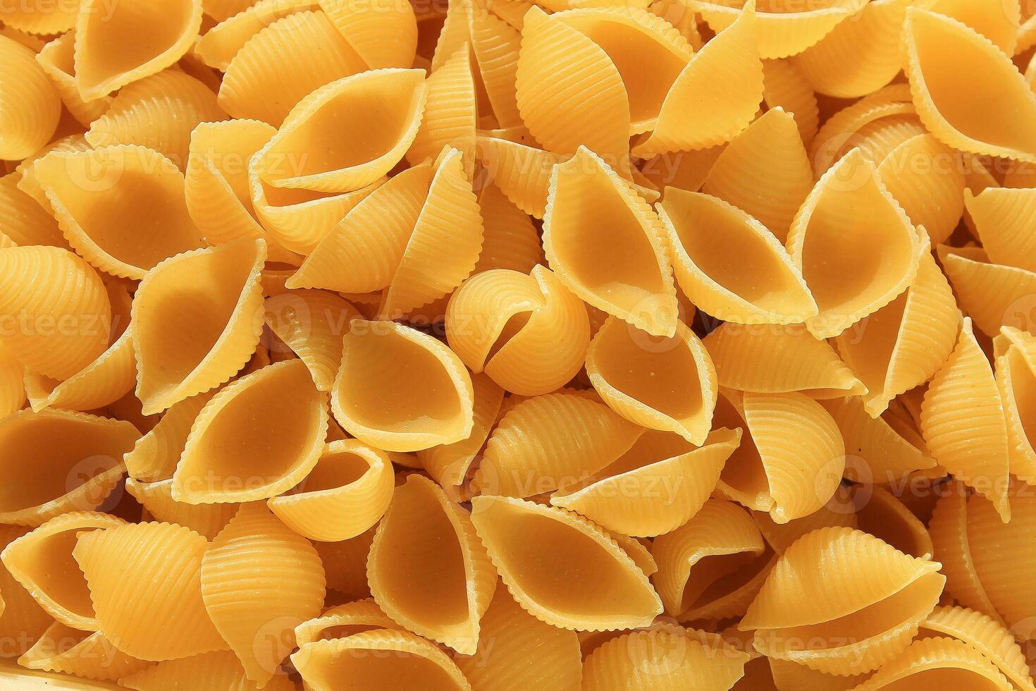 Figured paste in the form of a cochlea. Italian pasta conchiglie abstract backdrop. Texture. photo